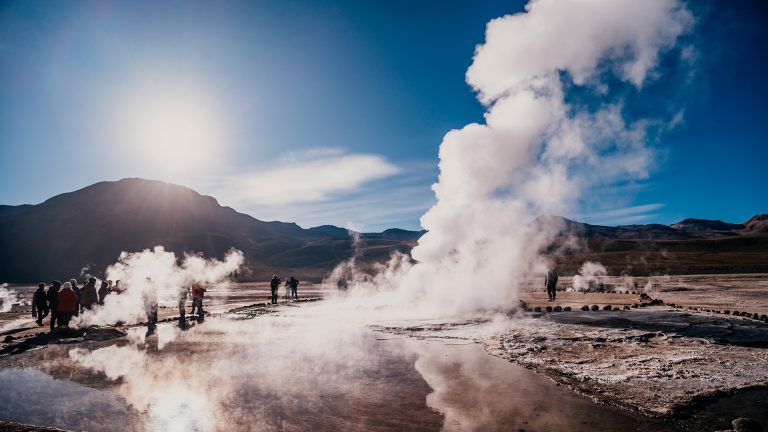 Pessoas contemplando as fumarolas no campo geotérmico Geyser el Tatio no Atacama