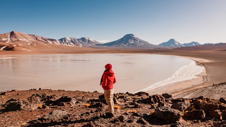 Viajante contemplando a Laguna Lejía no passeio das Miragens Andinas da FlaviaBia Expediciones no Deserto de Atacama