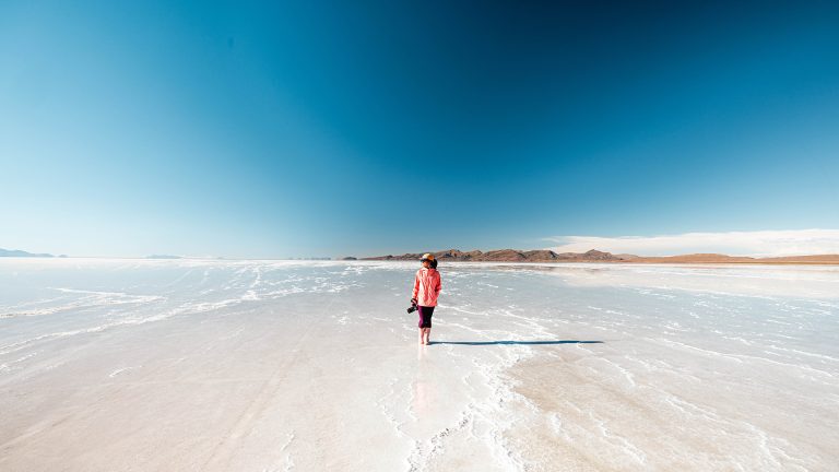 Mulher caminhando no salar de Uyuni alagado