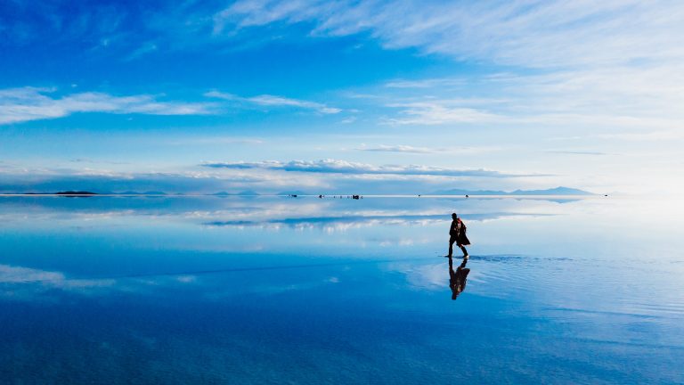 Homem caminhando no salar de Uyuni alagado